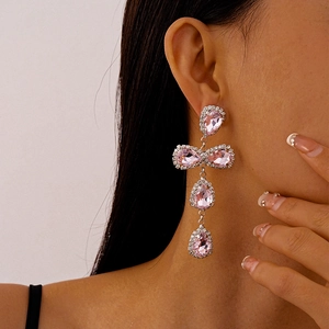 Close-up of model wearing pink teardrop crystal tassel earrings in silver finish