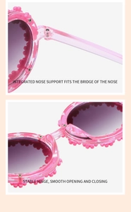 Detail view of pink kids sunglasses showing integrated nose pads and durable metal hinges