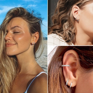 Close-up of sparkling silver hoop earrings and ear cuff stack on model's ear