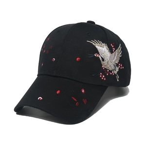 Black cotton baseball cap with Chinese style crane and floral embroidery from a side view