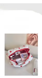 Detailed view of the red heart patterned cosmetic bag with a wide zipper opening