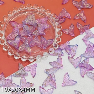 Macro detail of purple resin fish tail beads with gold foil for DIY jewelry making