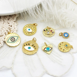 Collection of golden evil eye pendants with colorful zircon and enamel on white lace