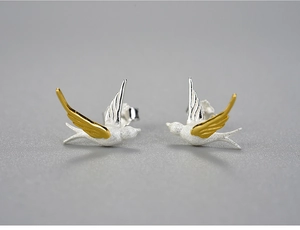 Vista macro di orecchini a lobo a rondine in argento 925 e design dorato minimalista