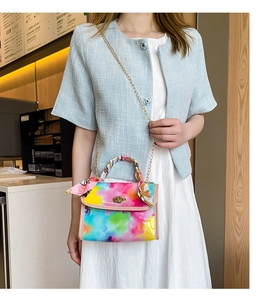 Detailed shot of rainbow crocodile texture bag with silk scarf handle and gold chain