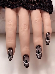 Close-up of long almond nails featuring black cat silhouettes and moon crescent art