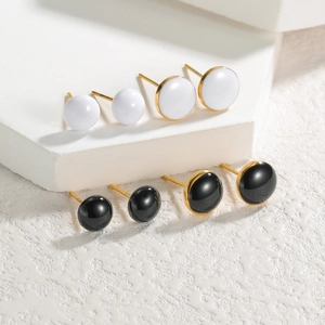 Détails macro des boucles d'oreilles dôme plaquées or 18 carats en émail noir et blanc