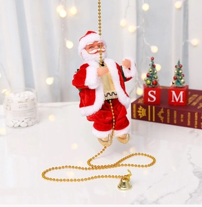 Detailaufnahme des kletternden Weihnachtsmanns an Goldperlenkette mit Weihnachtsdeko