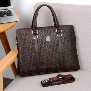 Dark brown business briefcase with embossed pattern and detachable strap on a chair
