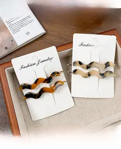 Detail of tortoise shell and marble acetate wave hair clips with handmade engraving