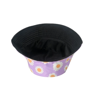 Women's purple cotton bucket hat featuring white daisy print and black lining for summer