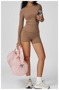 Détail de l'ensemble de yoga marron à manches longues et short taille haute sur mannequin