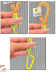 Detail of two-tone braided keychain with orange and green rope and yellow D-ring buckle