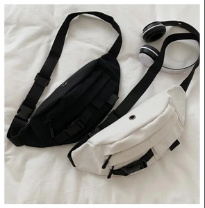 Detail view of canvas waist bags in black and white with adjustable straps and buckles