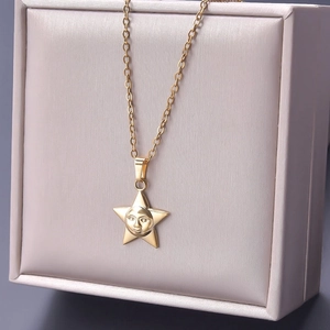 Detail of 18k gold plated stainless steel star pendant with sun face in a gift box