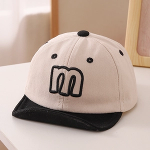 Close-up of baby baseball cap fabric texture with embroidered letter m smile design