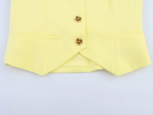 Vista dettagliata di un gilet giallo con chiusura a bottoni, tasche e l'orlo a punta