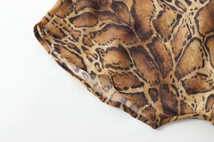 Macro detail of leopard print pattern and fine stitching on a chiffon midi dress