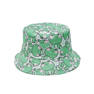 Close-up of fabric texture showing cute green cartoon frog print on the bucket hat