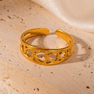 Detailed close-up of 18K gold hollow heart stainless steel ring on stone surface