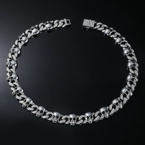 Detail of silver skull chain links with black crystal eyes and pavé rectangle clasp