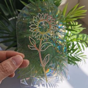 Handheld view of sunflower rainbow suncatcher film with holographic prism effect