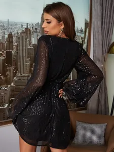 Dettaglio macro di paillettes nere lucide sulle maniche a campana del vestito da festa