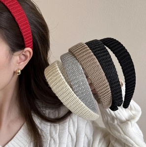 Set of five elegant knitted headbands in assorted colors shown by a fashion model