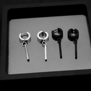 Unisex stainless steel drop earrings in silver and black hanging on a display tray