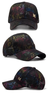 Detail of black mesh baseball cap with gold M logo and colorful camo print pattern