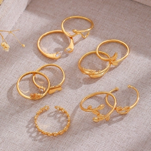 Detailed view of a 6-piece gold adjustable butterfly and heart toe ring set on linen