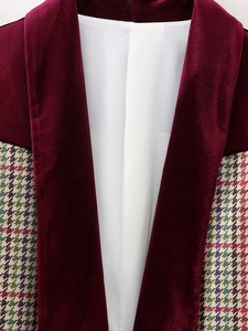 Detailed close-up of burgundy velvet splicing with colorful plaid fabric on jacket
