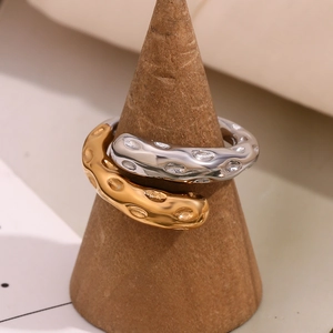 Dettaglio dell'anello placcato oro 18K con texture martellata su espositore in legno