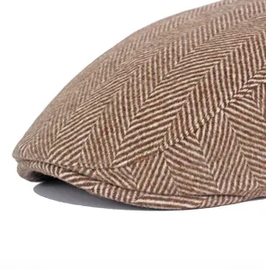 Macro shot of brown and white herringbone wool blend texture on a vintage flat cap