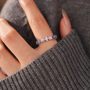 Close-up of silver ring with colorful cubic zirconia stones on a knitted background