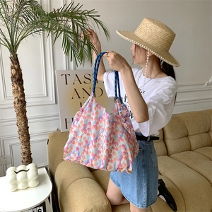 Detail of floral canvas tote bag with tulip pattern and blue braided rope handle