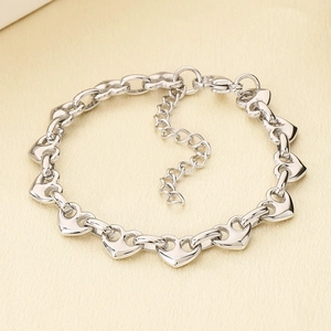 Detailed macro view of silver heart-link chain bracelet with adjustable lobster clasp