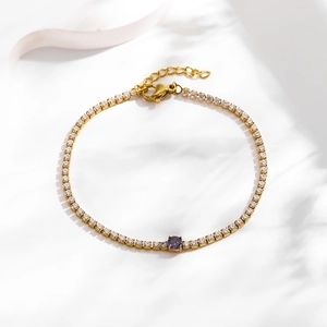Detailed view of gold tennis bracelet featuring purple zircon stone and lobster clasp