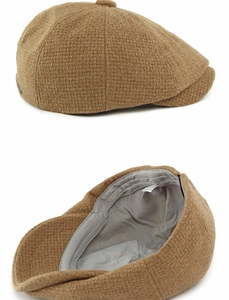 Close-up of brown wool blend newsboy hat with gray lining and internal care label