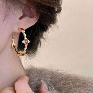 18k gold-plated C-shaped hoop earrings with tiger eye stone and crystals on a model