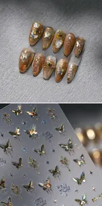 Macro view of holographic butterfly nail stickers with gold embossed textures and pearls