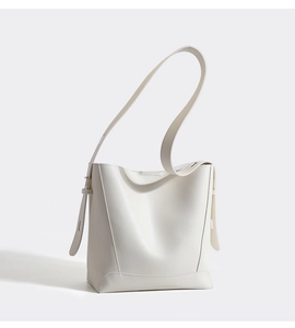 Detailed close-up of a white leather bucket bag with wide strap and metallic hardware