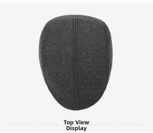 Top view of dark grey herringbone newsboy cap showing wool texture and stitching