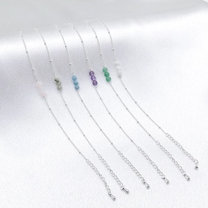 Detail of 925 silver beaded bracelets with natural stones on white satin background