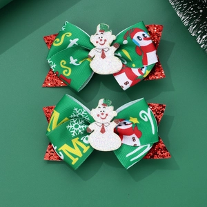 Detail of Christmas bow hair clips featuring glittery snowmen and red sequins