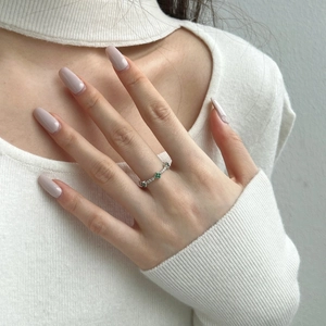 Detail of S925 sterling silver ring with green zircon clover on a model finger