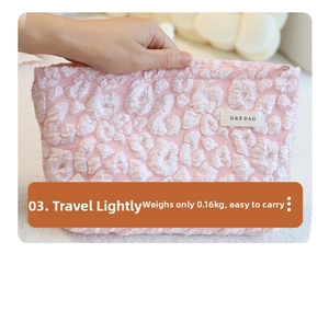 Macro shot of a pink cloud-embossed makeup bag with H&R logo in a soft plush setting