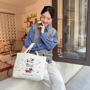 Close-up of heart-quilted white tote bag with cute dachshund and ribbon embroidery