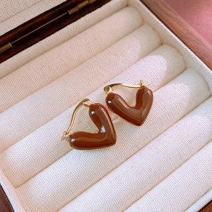 Detail of vintage heart earrings with brown enamel finish in a wooden jewelry box