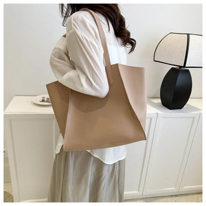Lifestyle shot of large beige tote bag worn on shoulder for a minimalist daily look
